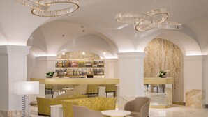 Un hall con zona de bar, asientos y una pared decorativa.