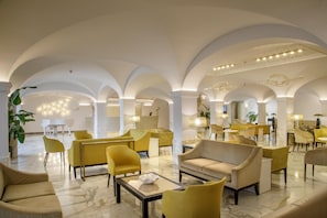 A spacious lobby with high ceilings, arched columns, and a mix of seating areas. - Hotel Shangri-La Roma by OMNIA hotels (Rome)
