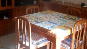 A dining area with a wooden table and chairs, a cabinet with glass doors, and wall-mounted pictures. - "L'Antica Locanda" House (Catona)