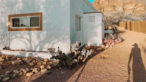 A white building with a window and a door, surrounded by rocks and cacti. - Casita at base of the Superstition Mountains. Unbelievable hiking and views. (Apache Junction)