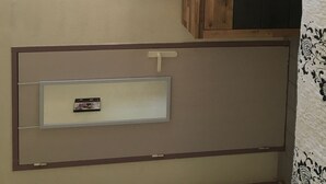 A bedroom with a wooden wardrobe, a small TV, and a framed artwork on the wall. - typical small house, air-conditioned fisherman's farmhouse (swimming pool, jacuzzi, sauna, fitness room) (Le Barcarès)