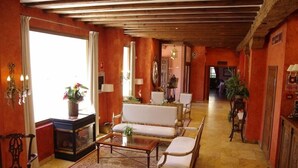A spacious living room with a fireplace, sofas, and a coffee table. - Palacio Azcarate Hotel (Ezcaray)