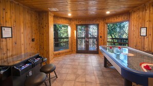 A pool table with stools, a pool table with balls, and a door leading to an outdoor deck. - Four Seasons (Yosemite)