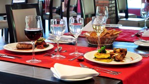 Una tavola imbandita con piatti di cibo, bicchieri da vino e posate.