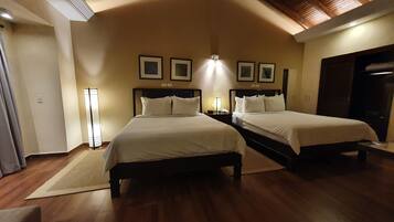 Une chambre d’hôtel avec deux lits, un grand miroir et des tableaux encadrés accrochés au mur.