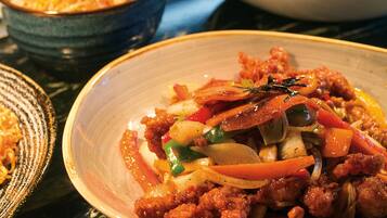 A table with various dishes, including a bowl of stir-fried vegetables and meat, and a bowl of noodles.