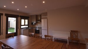 Een moderne keuken met een eethoek, een houten tafel en stoelen.