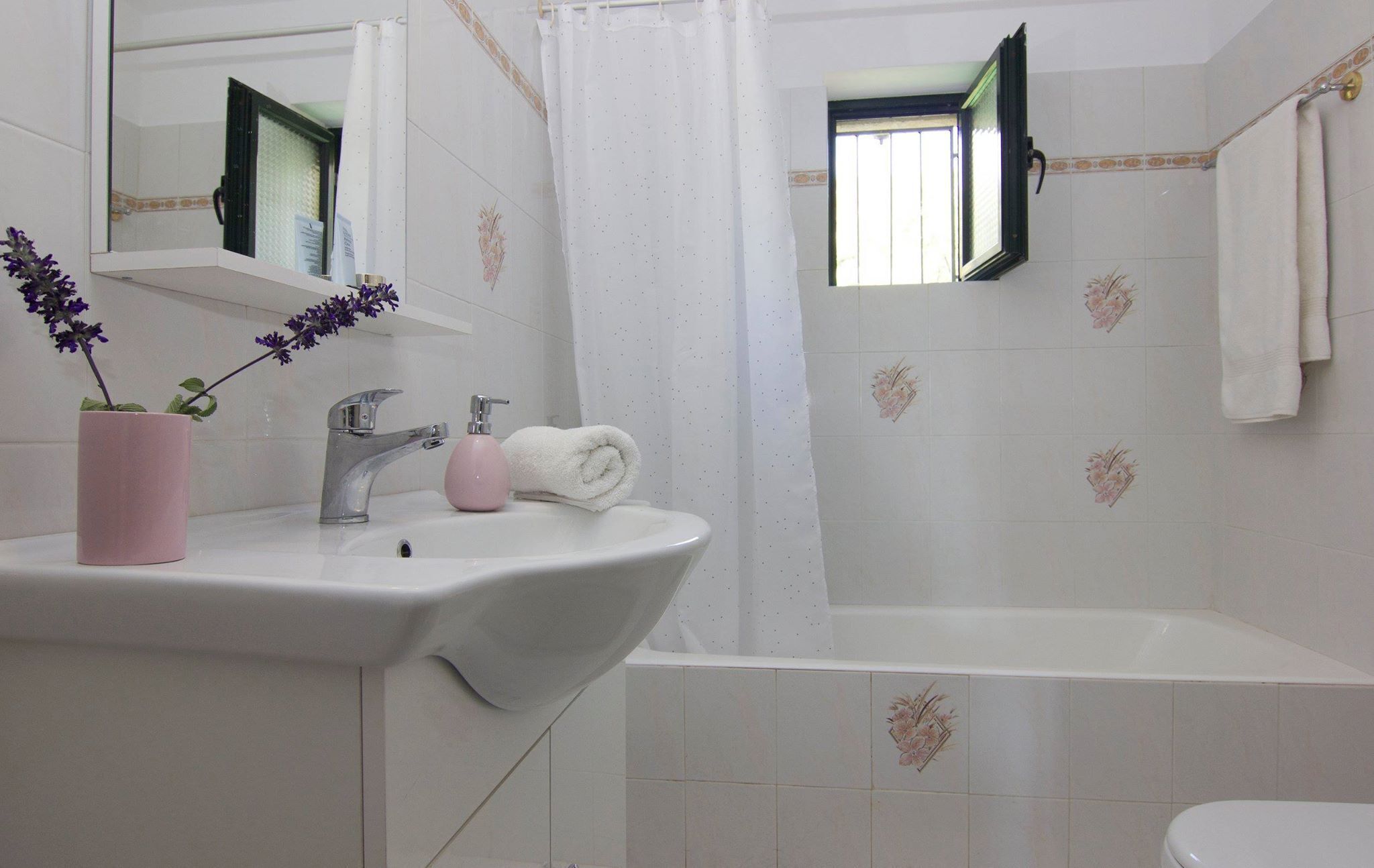 A bathroom with a sink, mirror, and shower.