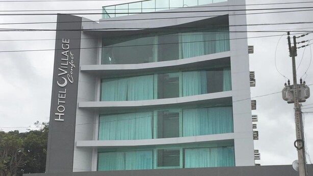 Een hotel met meerdere verdiepingen, met een modern ontwerp en een opvallend bord aan de gevel.