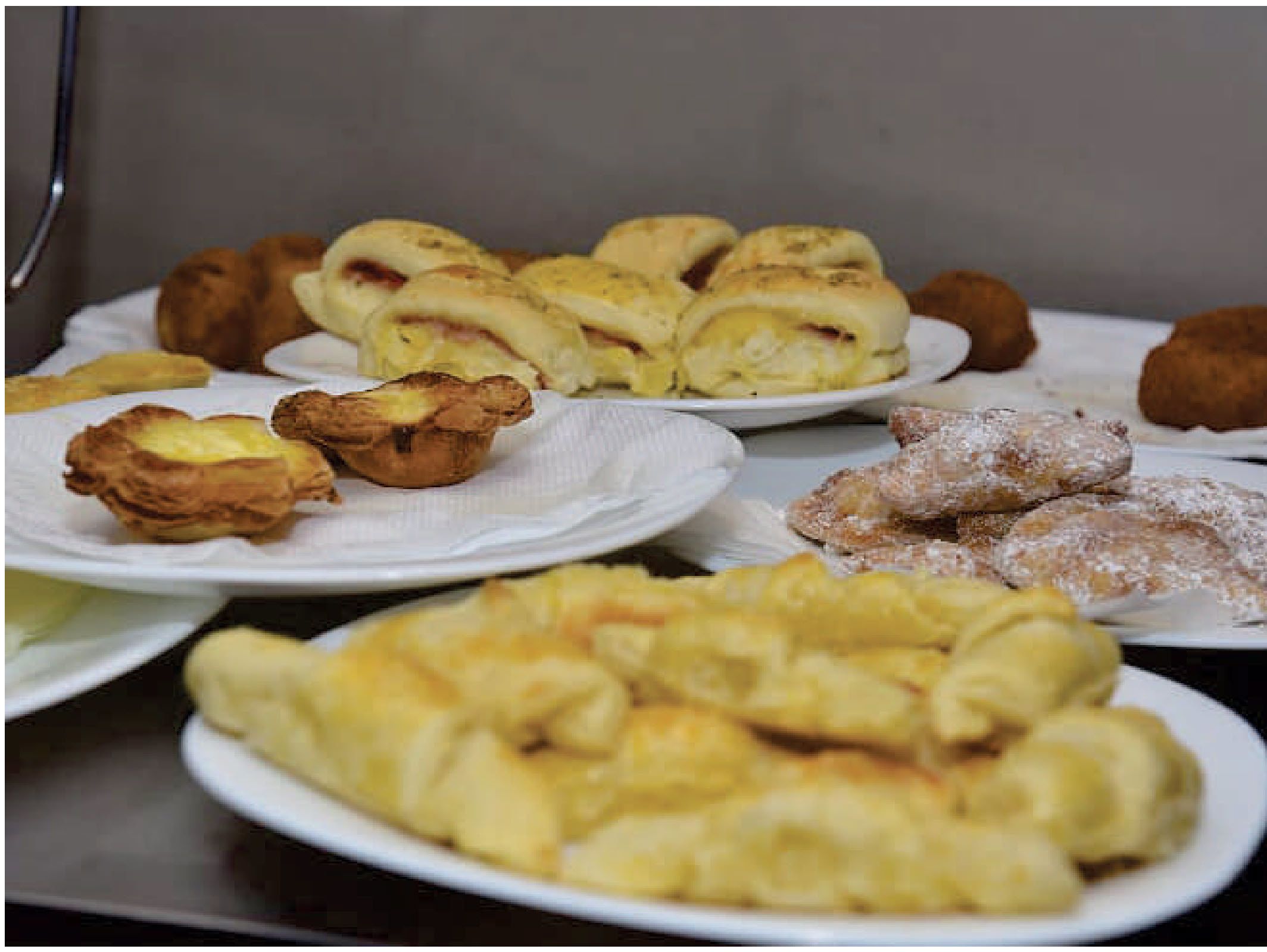 Diversos pastéis em pratos, incluindo folhados e recheados.