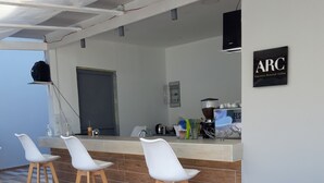 A modern interior with a kitchen area, white bar stools, and a coffee station. - Sea Vessel (Mylopotamos)