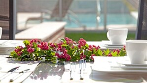 A dining table set for a meal with white plates, silverware, and cups, accompanied by a floral centerpiece. - 5***** Luxury pool villa, very quiet location, free WLAN, heated pool, 3000 sqm  (Boltenhagen)