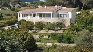 A two-story house with a balcony, surrounded by greenery and hills in the background. - Ground floor of villa-house, T3 apartment 10 min from Ajaccio with swimming pool. (Afa)