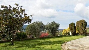 A stone pathway leading through a well-maintained garden with various shrubs and trees. - Ground floor of villa-house, T3 apartment 10 min from Ajaccio with swimming pool. (Afa)