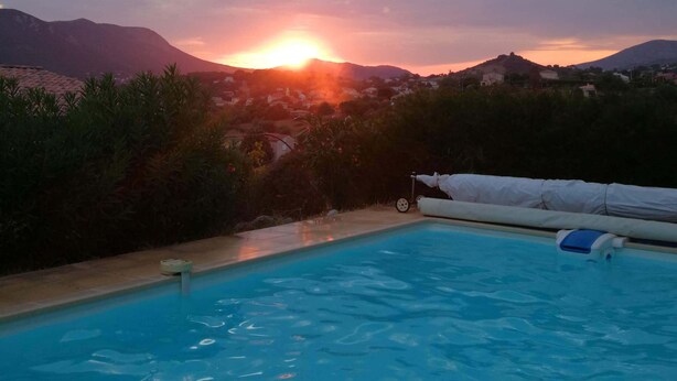 A swimming pool with a view of the sunset over mountains and a clear sky. - Ground floor of villa-house, T3 apartment 10 min from Ajaccio with swimming pool. (Afa)