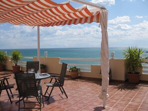 A terrace with a table and chairs, potted plants, and a view of the sea. - panoramic terrace air-conditioned apartment 2 bedrooms 4 pers (Peñíscola)