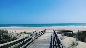 A wooden boardwalk leading to a beach with clear skies. - Private flat with sea view in a complex with great swimming pool area. (Lagos)