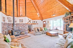 Una sala de estar acogedora con chimenea, techo de madera y asientos cómodos.