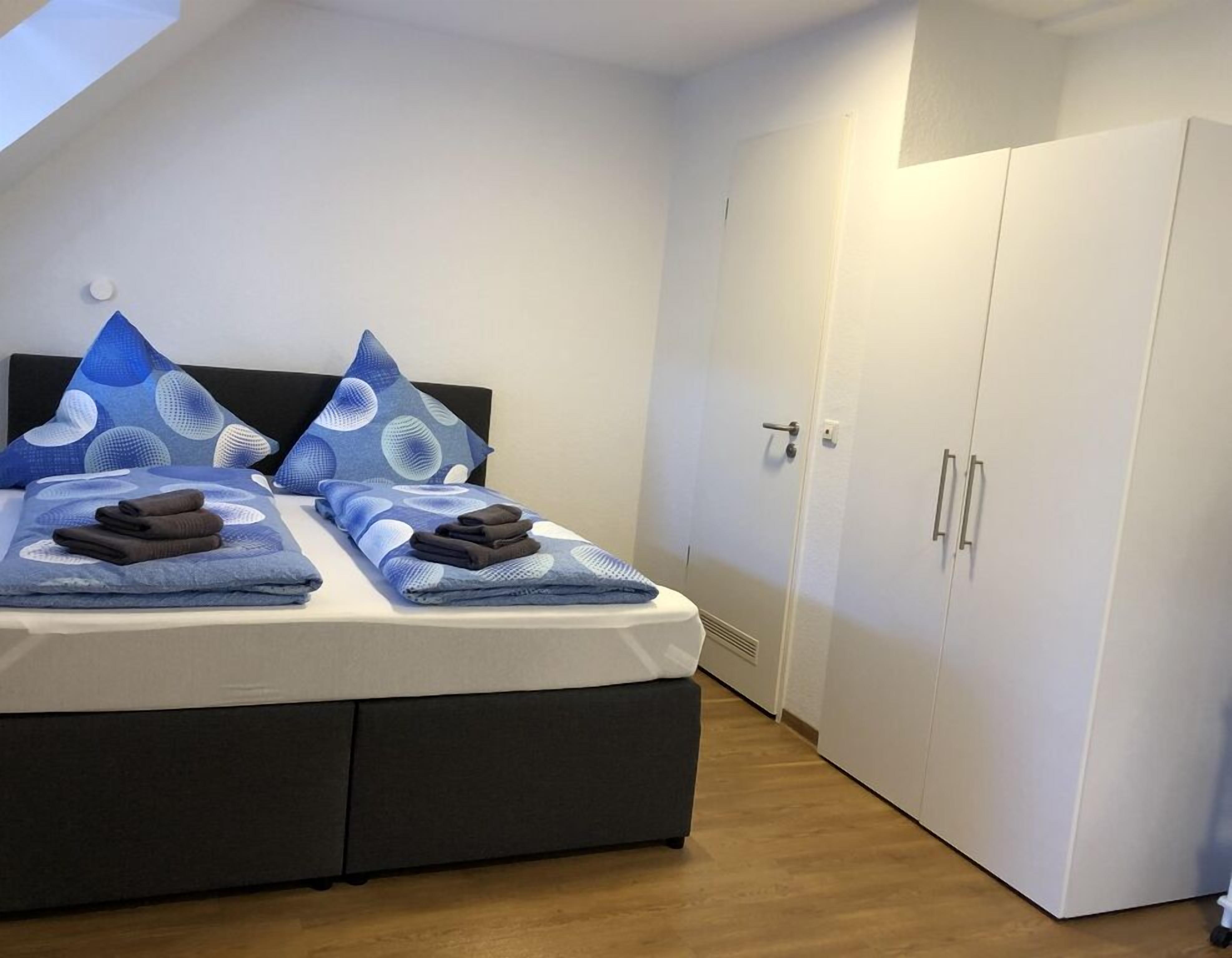 Ein Schlafzimmer mit Bett, Kissen und Kleiderschrank.
