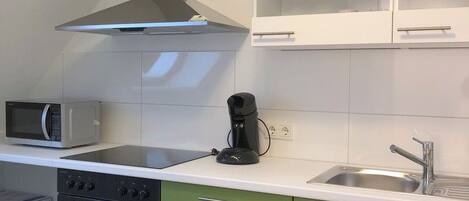 A compact kitchen with a microwave, stove, and oven.