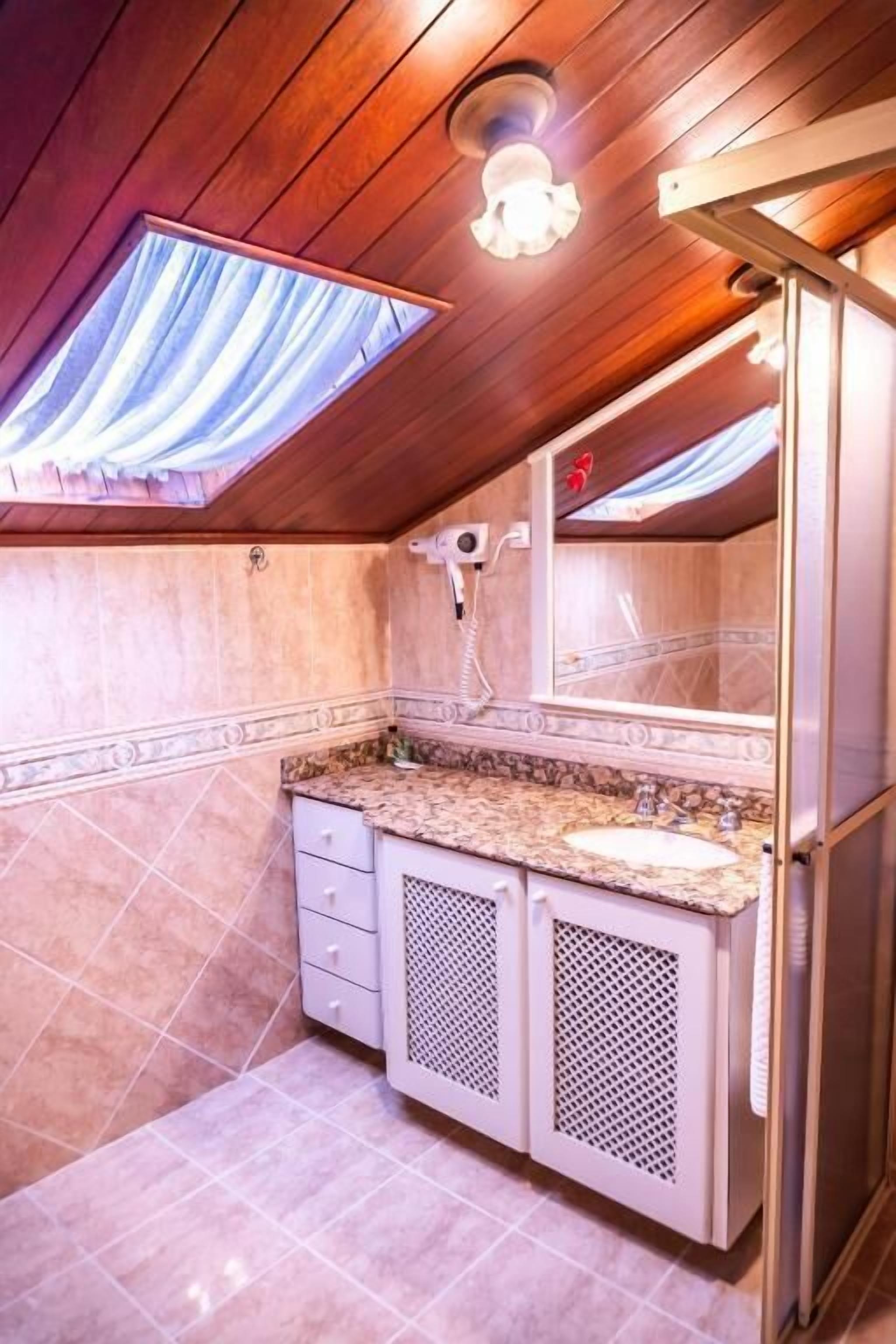 Une petite salle de bain comprenant un meuble-lavabo, un évier et un miroir.