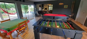 Ein Raum mit Kicker-, Billard- und Pooltisch.