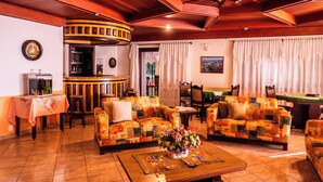 Ein gemütliches Wohnzimmer mit zwei Sofas, einem Couchtisch mit floralem Mittelstück, einer Bar und einem Esstisch.