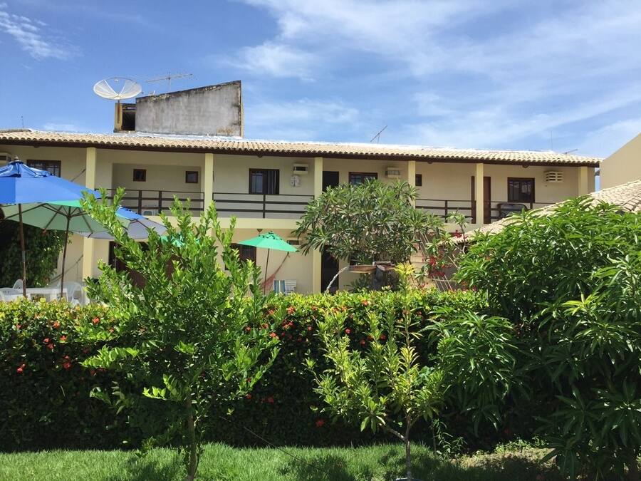 Un edificio con techo de tejas, varias ventanas y una antena parabólica.