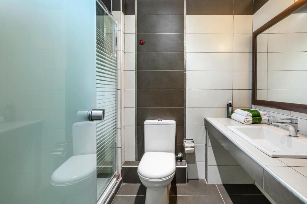 A modern bathroom with a toilet, bidet, and sink.