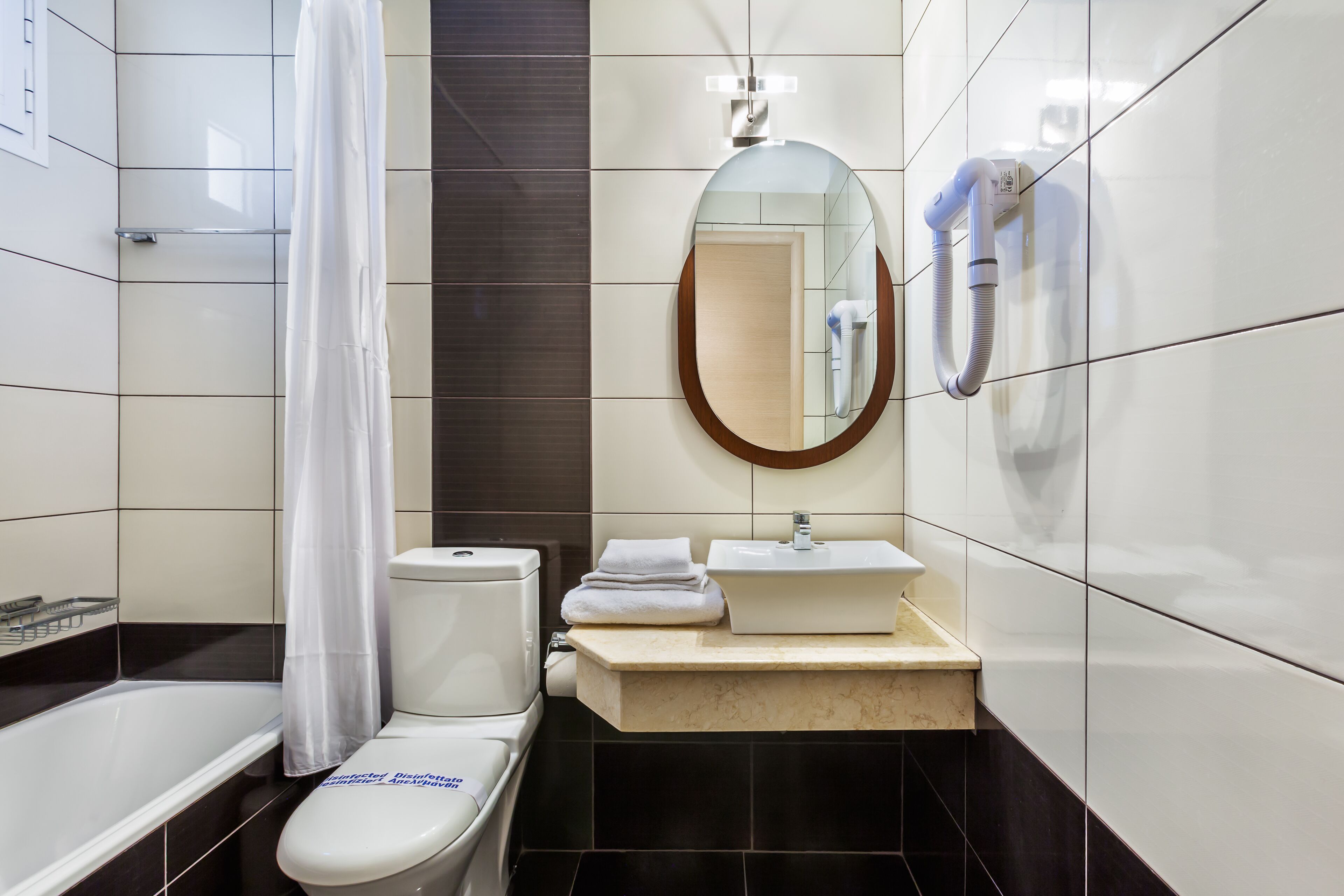 A modern bathroom with a bathtub, toilet, and sink.