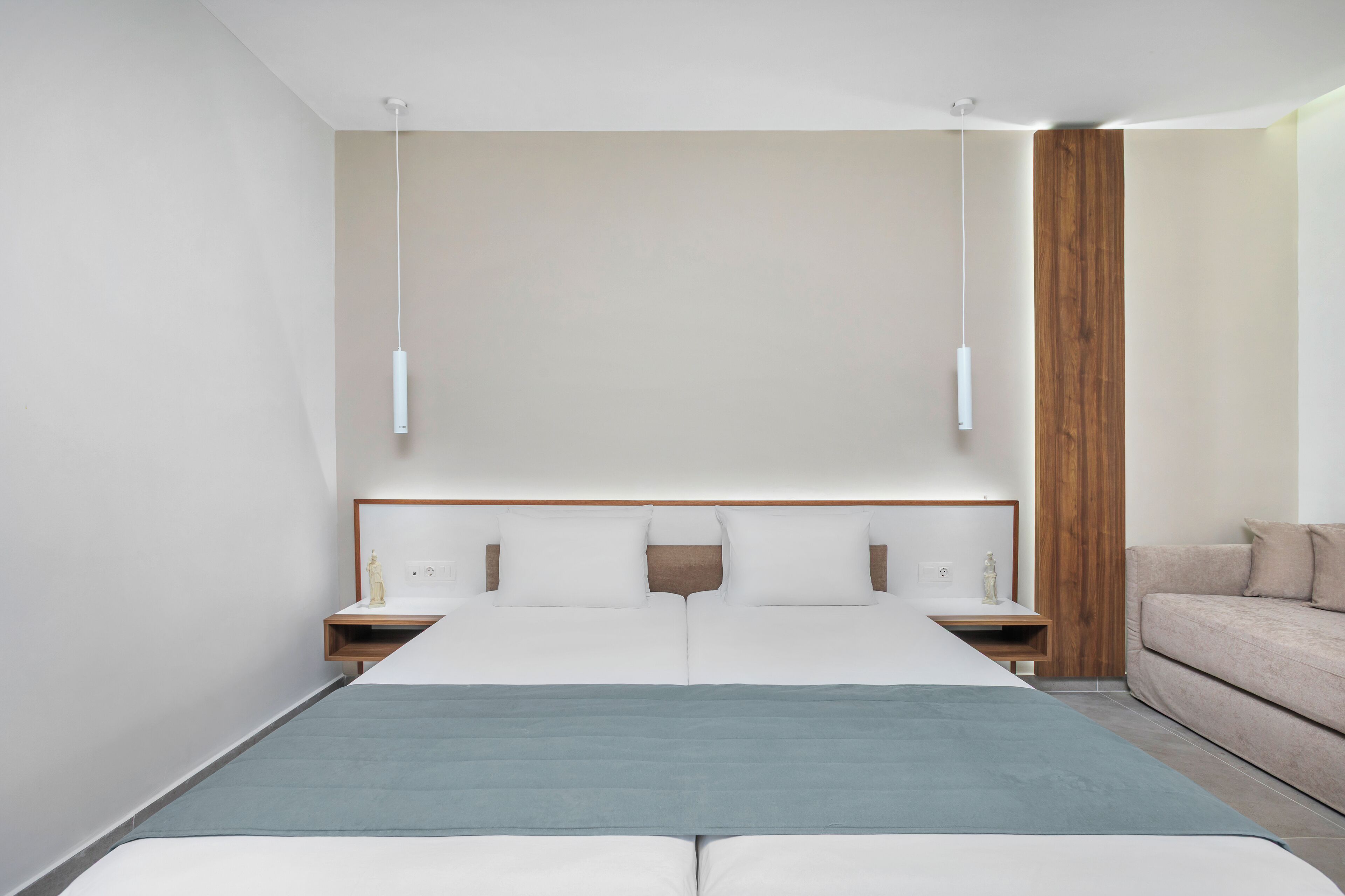 Un dormitorio moderno con una cama grande, mesitas de noche, una pared decorativa de madera y una paleta de colores neutros.