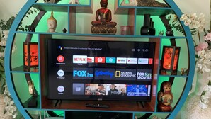 A television mounted on a teal-framed shelf with various decorative items and a search bar displaying streaming services. - PACOTTE, nice living villa with private (Rawai)