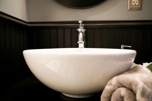 Een bad/douchecombinatie, handdoeken, toiletpapier