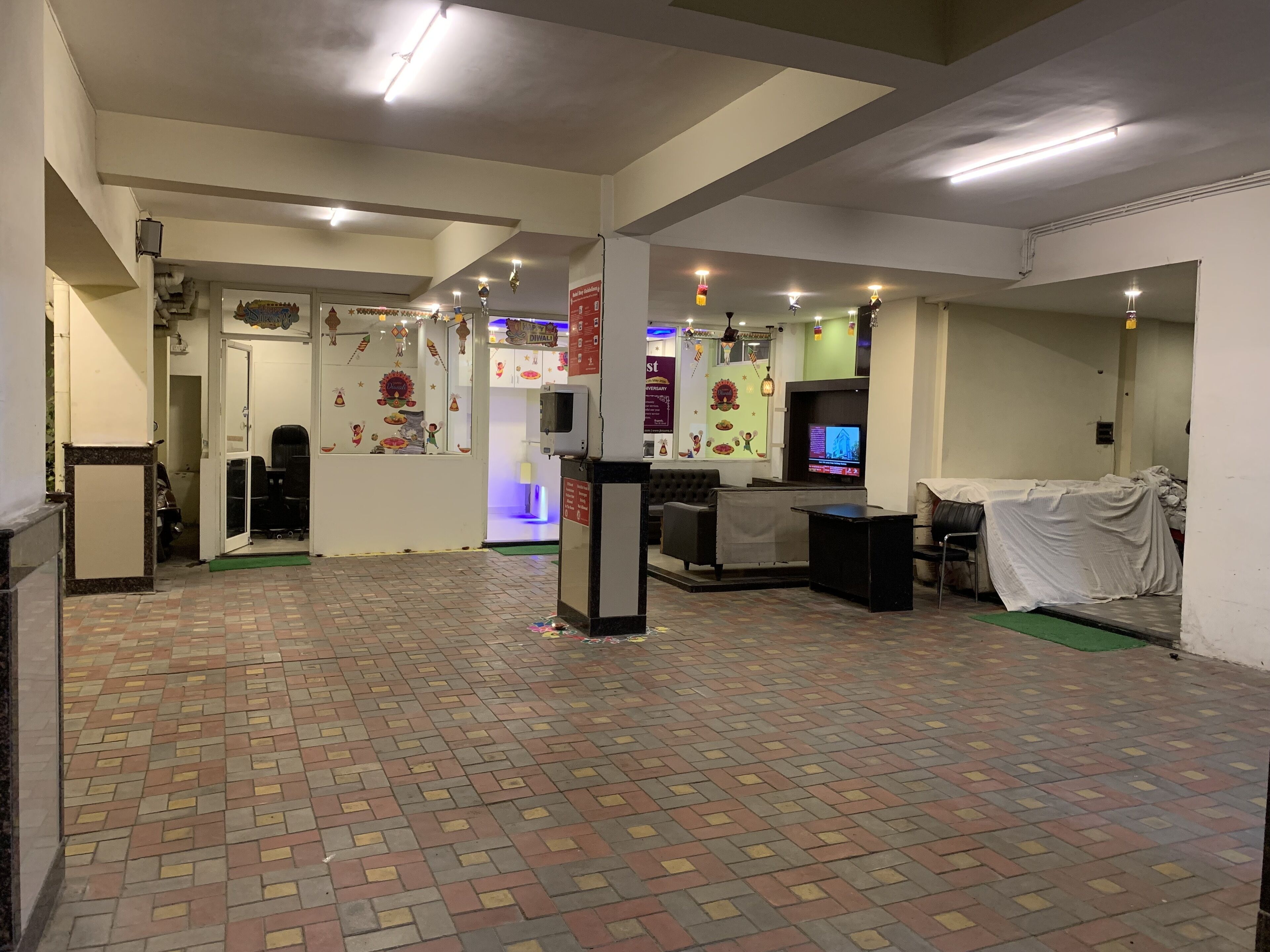 Un hall d’entrée spacieux, doté d’un sol à motifs, d’un comptoir de réception et d’un téléviseur.
