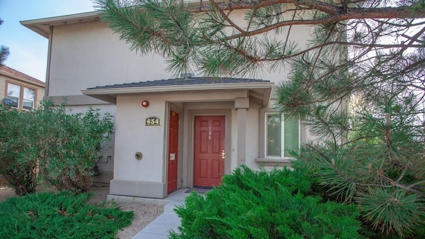 A two-story building with a red door and a mailbox.