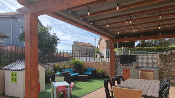 A covered patio area with a wooden pergola, outdoor seating, a barbecue grill, and a small playhouse. - Casa Rinconeda Promotion from August 1 to 13 (Polanco)