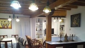 A dining area with a wooden table and chairs, a kitchen area with a counter and cabinets, and a tiled floor. - Casa Rinconeda Promotion from August 1 to 13 (Polanco)
