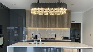 Una cocina moderna con una isla central, una araña y armarios de madera.