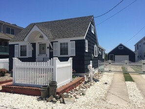 A two-story house with a dark exterior, white shutters, and a white picket fence. - Cape May Fisherman's Cottage Located on historic Yacht Avenue in Cape May (Cape May)
