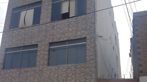 Ein mehrgeschossiges Gebäude mit einer Steinfassade und großen Fenstern.