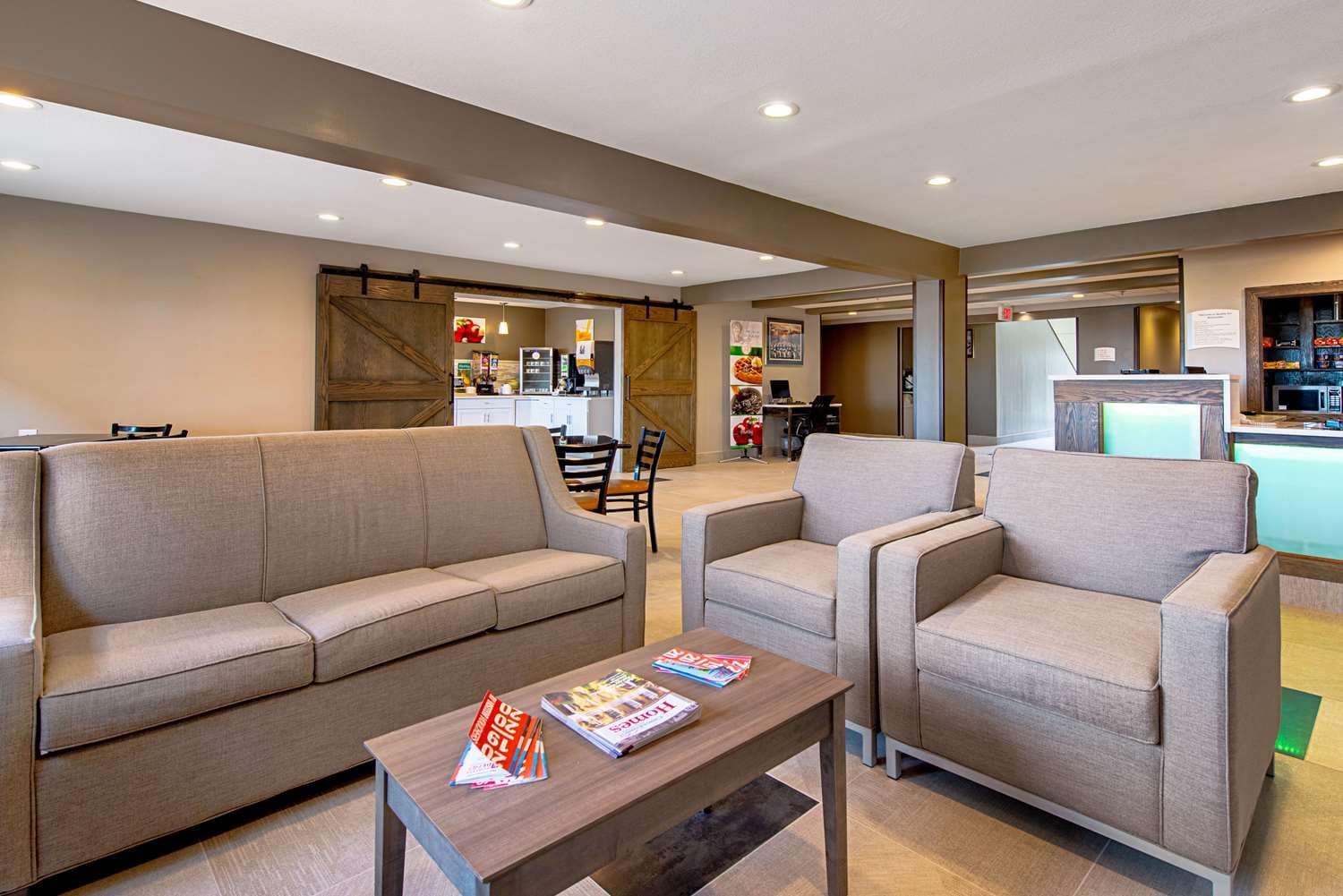 A modern living area with a sofa, armchairs, and a coffee table.
