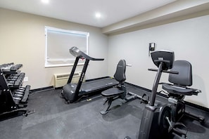 A gym with a treadmill, bench press, and dumbbells. - Quality Inn of Mishawaka (Mishawaka)