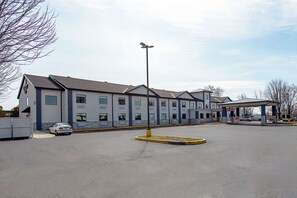 A multi-story hotel with a parking lot and a covered outdoor area. - Quality Inn of Mishawaka (Mishawaka)
