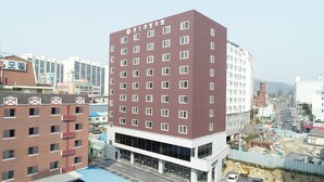 Un hôtel à plusieurs étages, avec une façade rouge et une enseigne en langue étrangère.