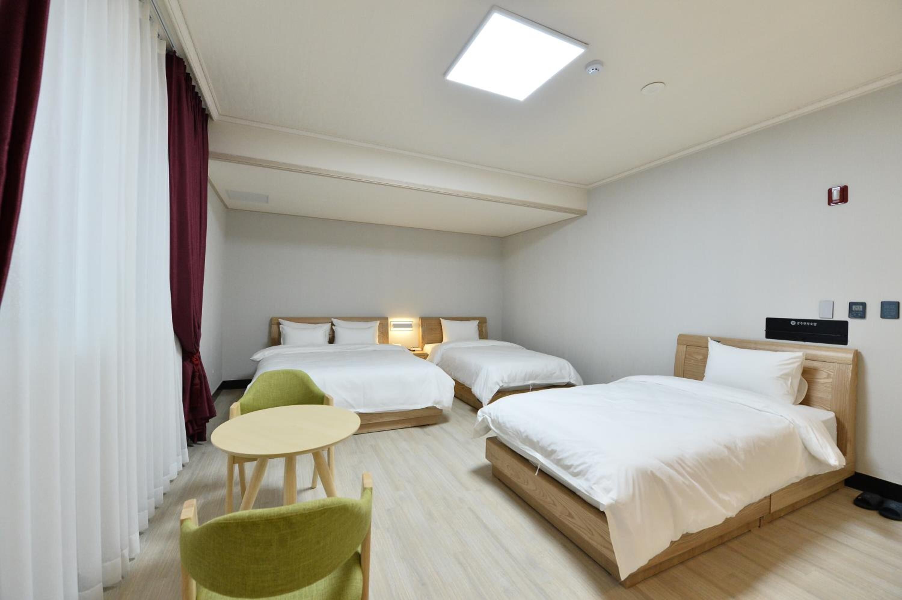 Una camera d'albergo con due letti, un tavolino e una sedia.