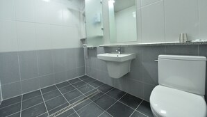 Une salle de bain avec des toilettes, un lavabo et un miroir.
