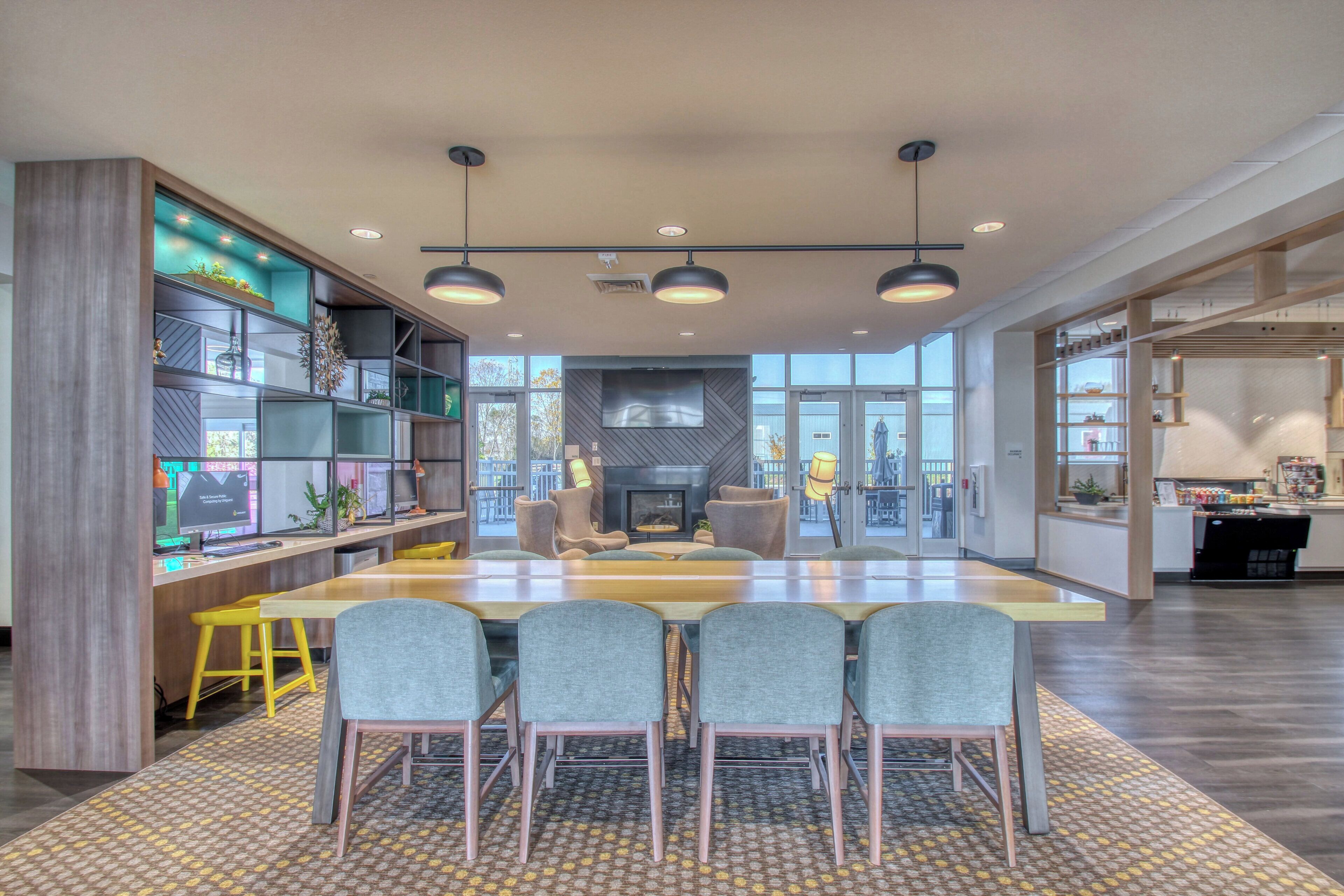 A modern conference room with a large table, four chairs, and a fireplace.
