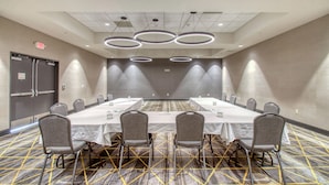 A conference room with a long table, chairs, and a carpeted floor. - Holiday Inn Appleton by IHG (Appleton)