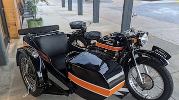 A vintage motorcycle with a sidecar parked outside a building.