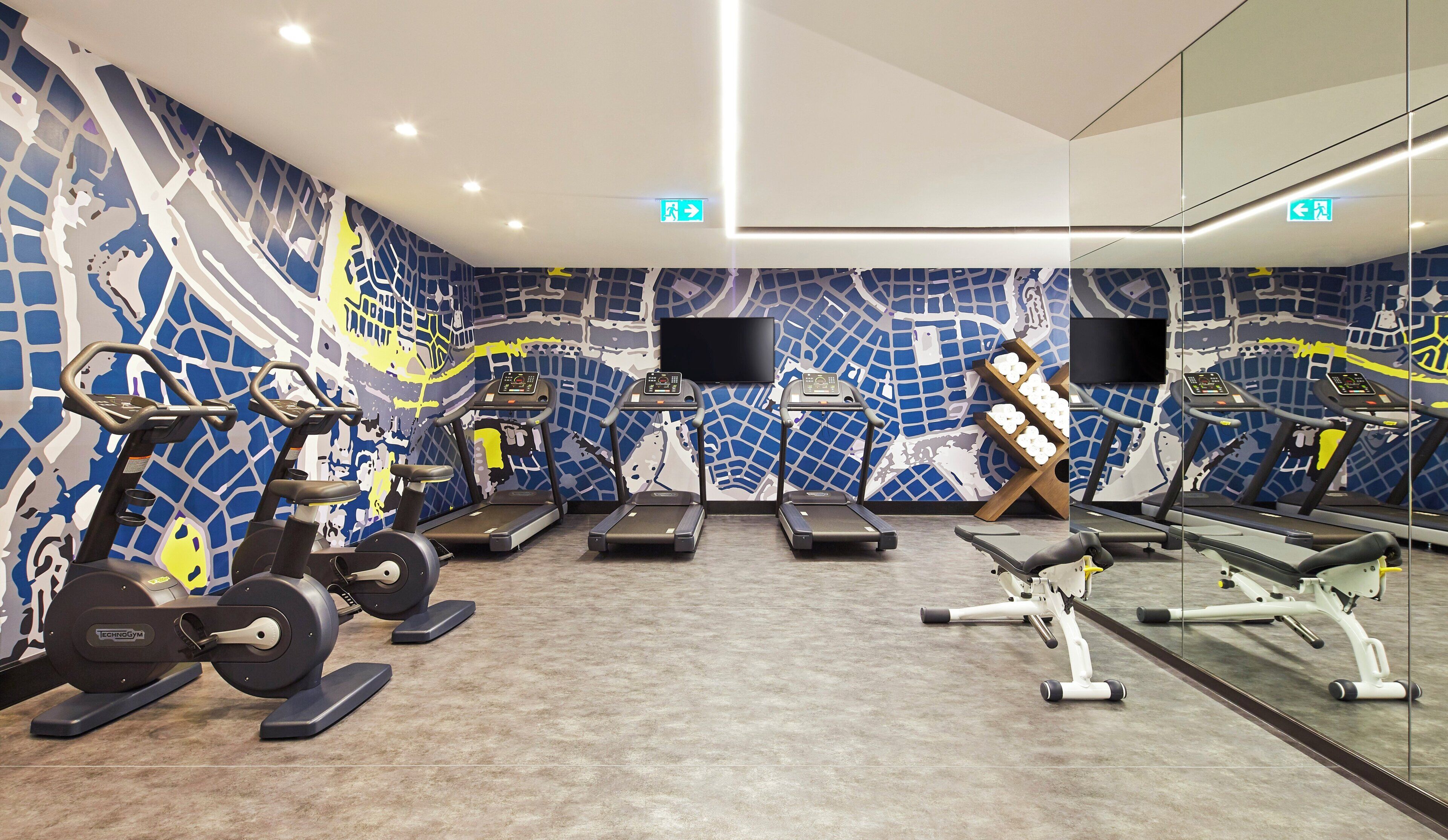A gym with treadmills, ellipticals, and a rowing machine.